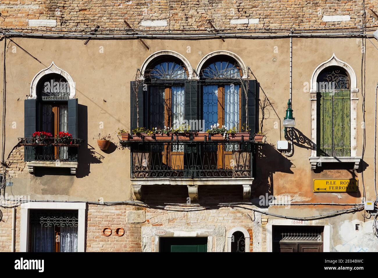 Alte traditionelle venezianische Gebäudefassade mit Balkon und hölzernen Fensterläden in Venedig, Italien Stockfoto
