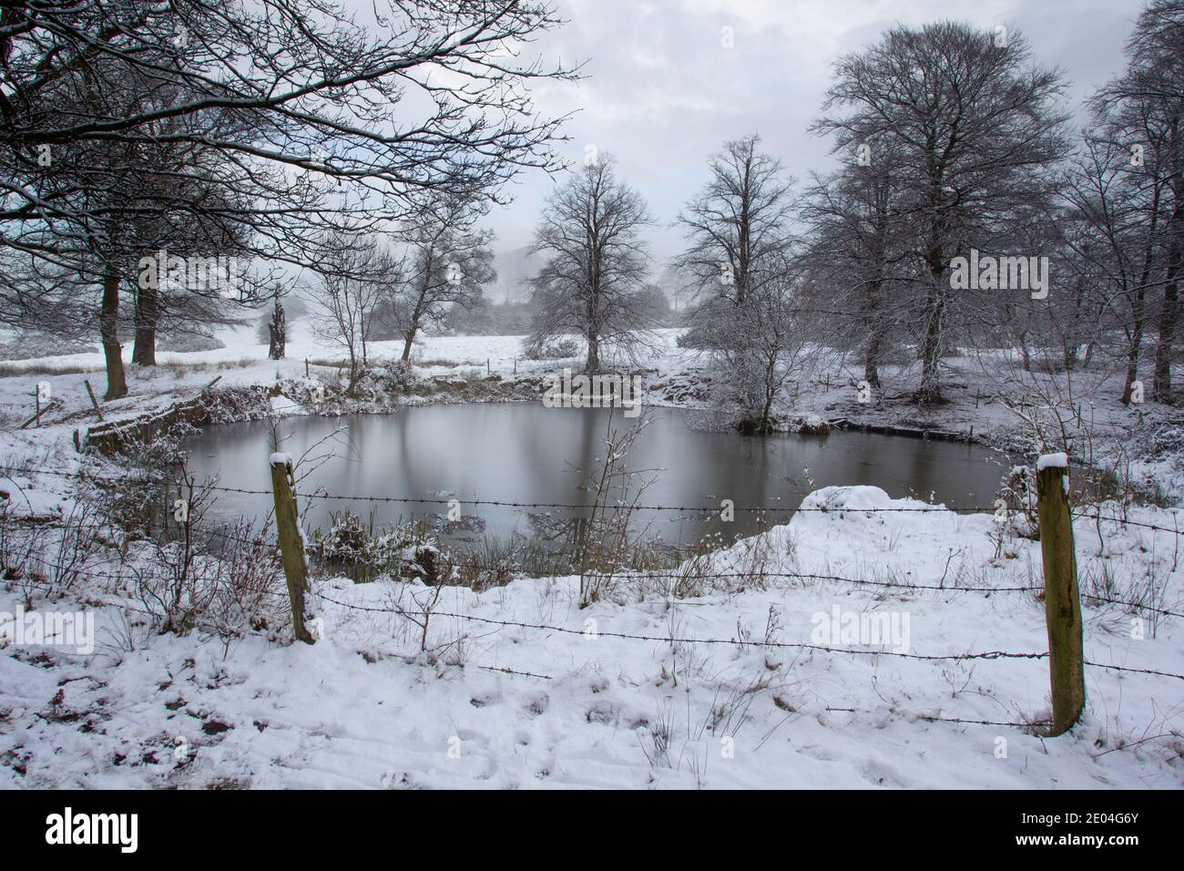 Kleiner Teich in verschneiter Landschaft, Cheshire, Großbritannien Stockfoto