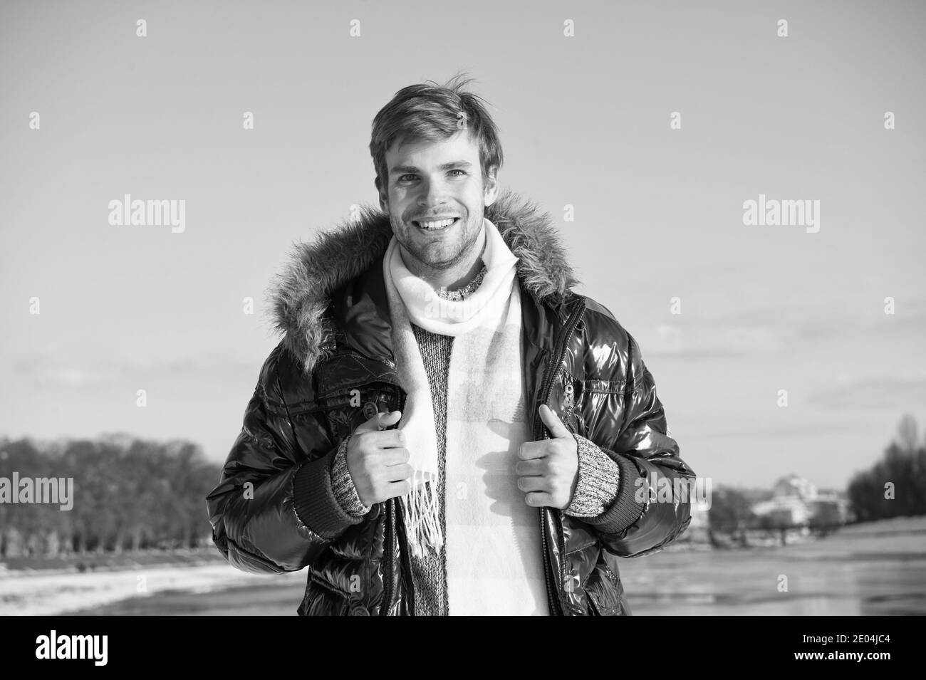 Freizeitkonzept. Aktive Freizeit. Ein gutaussehender Mann, der im Winter unterwegs ist. Warme Kleidung für kalte Jahreszeit. Wintermode. Winterferien. Wandern verschneite Natur Hintergrund. Mann genieße januar im Freien. Stockfoto
