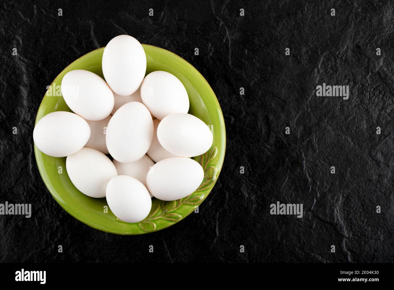Ein paar rohe Eier auf dem grünen Teller Stockfoto