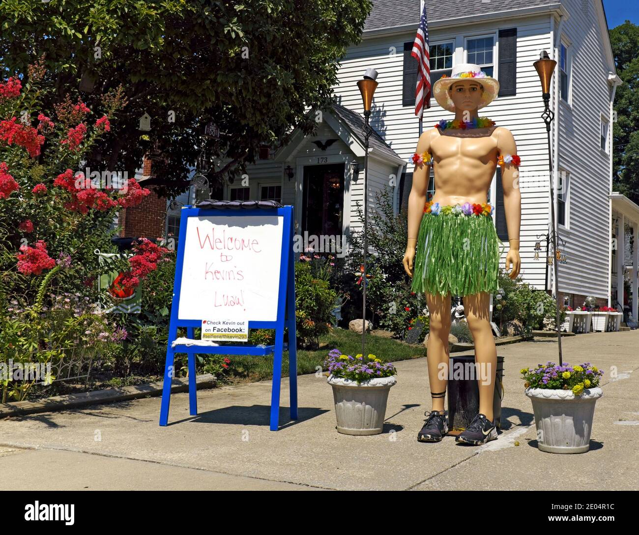 Kevin, die Schaufensterpuppe, ist in einem Luau Rock und Hut ohne Hemd gekleidet. Die Auffahrt Diorama wechselt täglich unterhaltsam Nachbarn und Besucher. Stockfoto