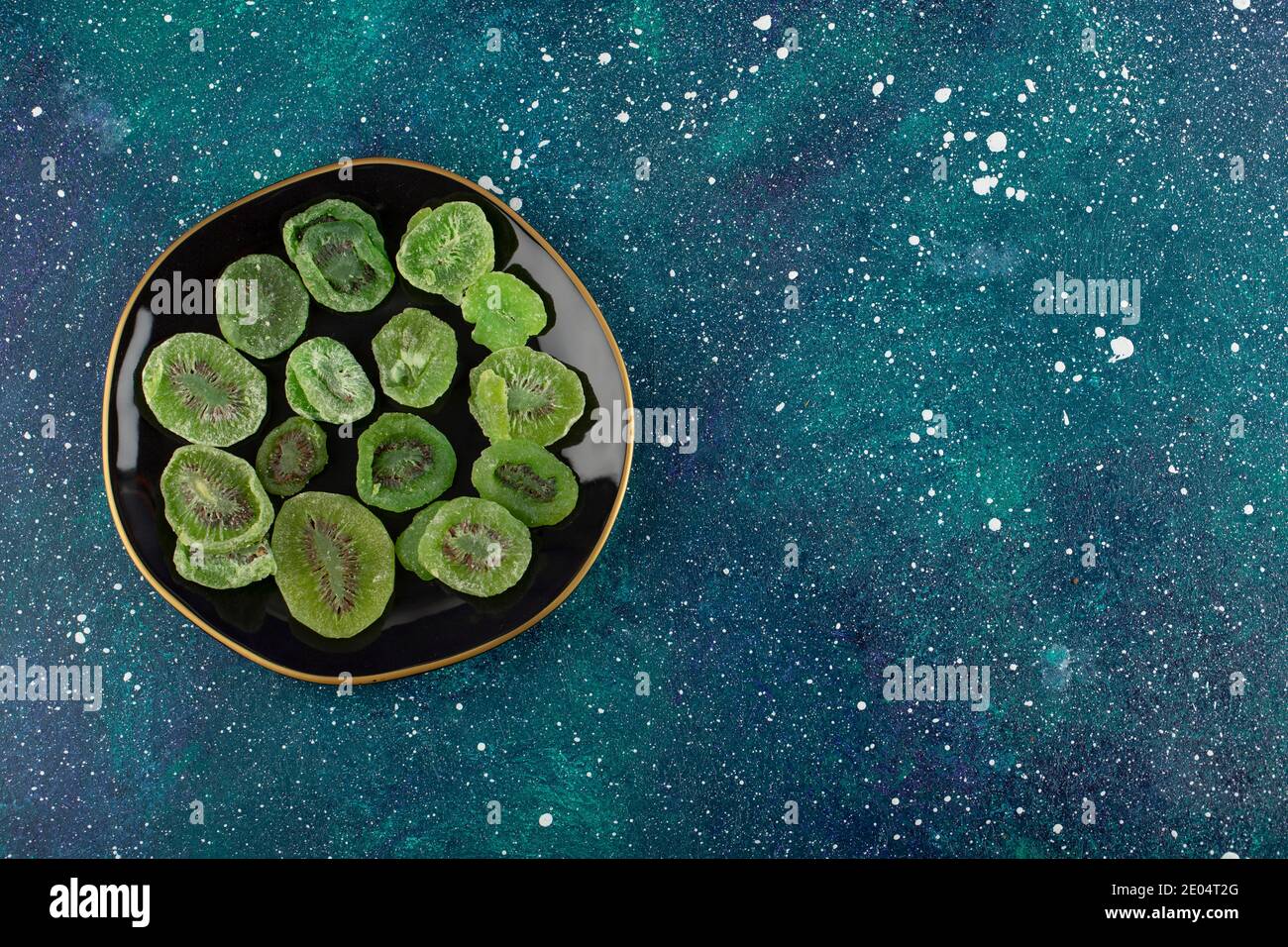 Getrocknete Kiwi-Scheiben auf schwarzem Teller Stockfoto