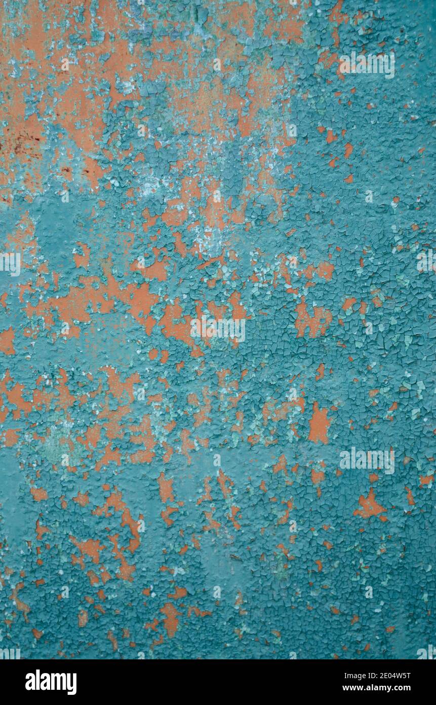 Vertikaler Hintergrund alte rissige Farbe auf Zaun, Grundierung orange, abblätternde Farbe grün Stockfoto
