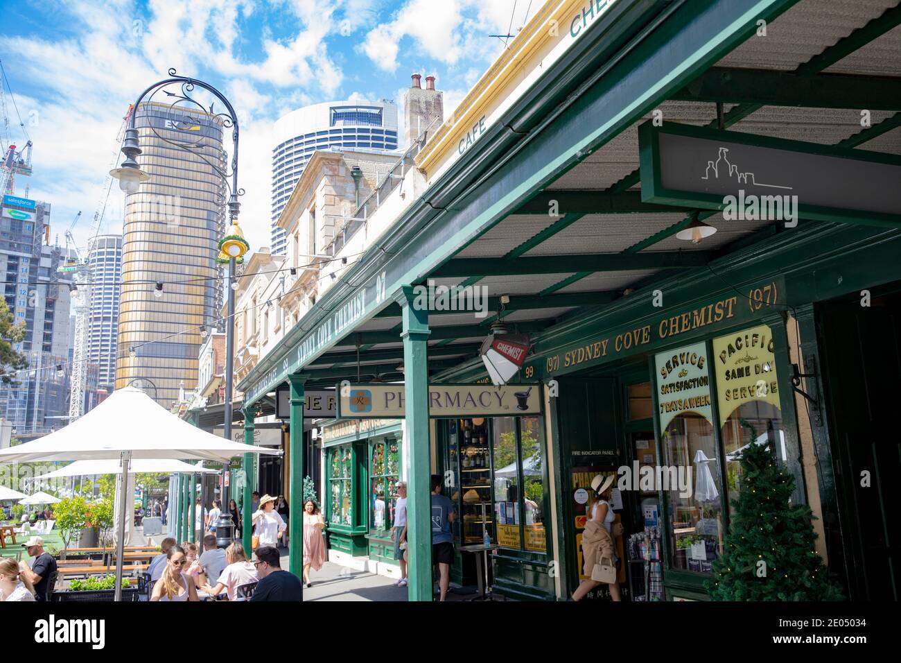 Sydney und die Colonial Rocks Gegend an einem Sommertag, Leute im The Rocks Café für Essen und Trinken mit Firmenbüros im Stadtzentrum hinter, NSW Stockfoto