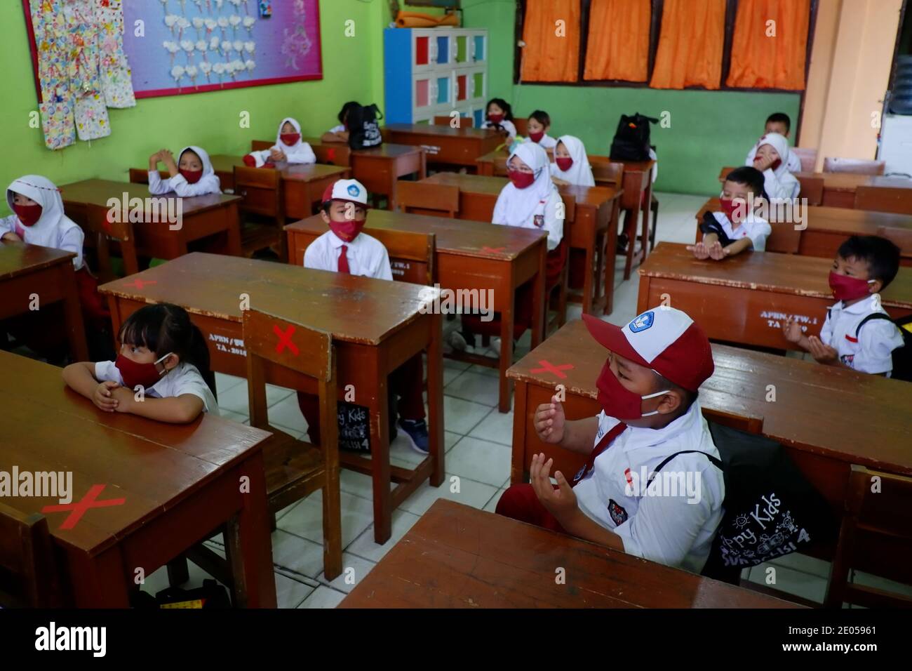 Eine Gruppe von Grundschülern mit Gesichtsmasken in einem Klassenzimmer. Stockfoto