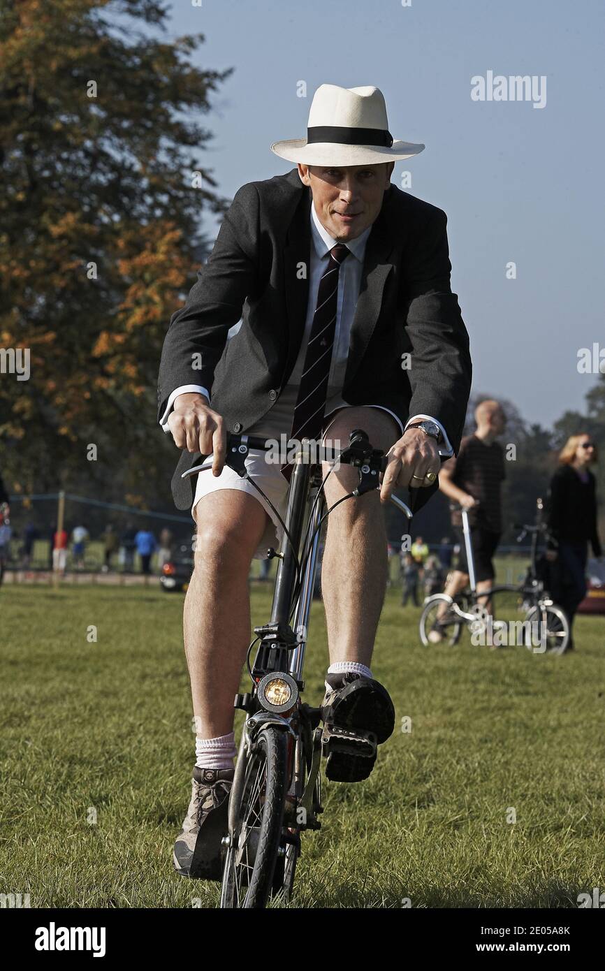 Mann mit Krawatte und Hut auf Brompton-Fahrrad bei der Brompton-Weltmeisterschaft, die im Blenheim Palace, Großbritannien, stattfand. Stockfoto
