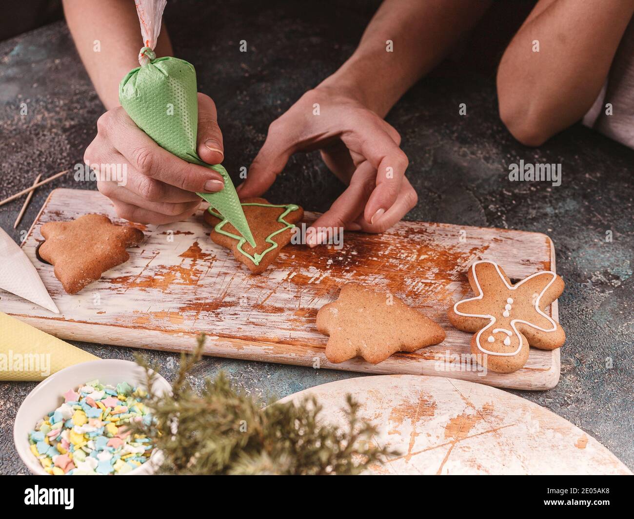 Mama lehrt ihre Tochter Lebkuchen zu dekorieren. Hausgemachte traditionelle Weihnachtsgebäck. Köstliches Dessert. Stockfoto