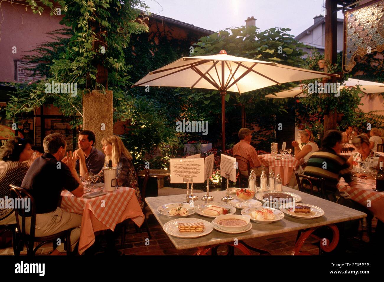 Kleine Gruppe von Männern und Frauen sitzen und trinken im rustikalen Georges Blanc Restaurant in Vonnas, in der französischen Provinz Bresse, Frankreich. Stockfoto