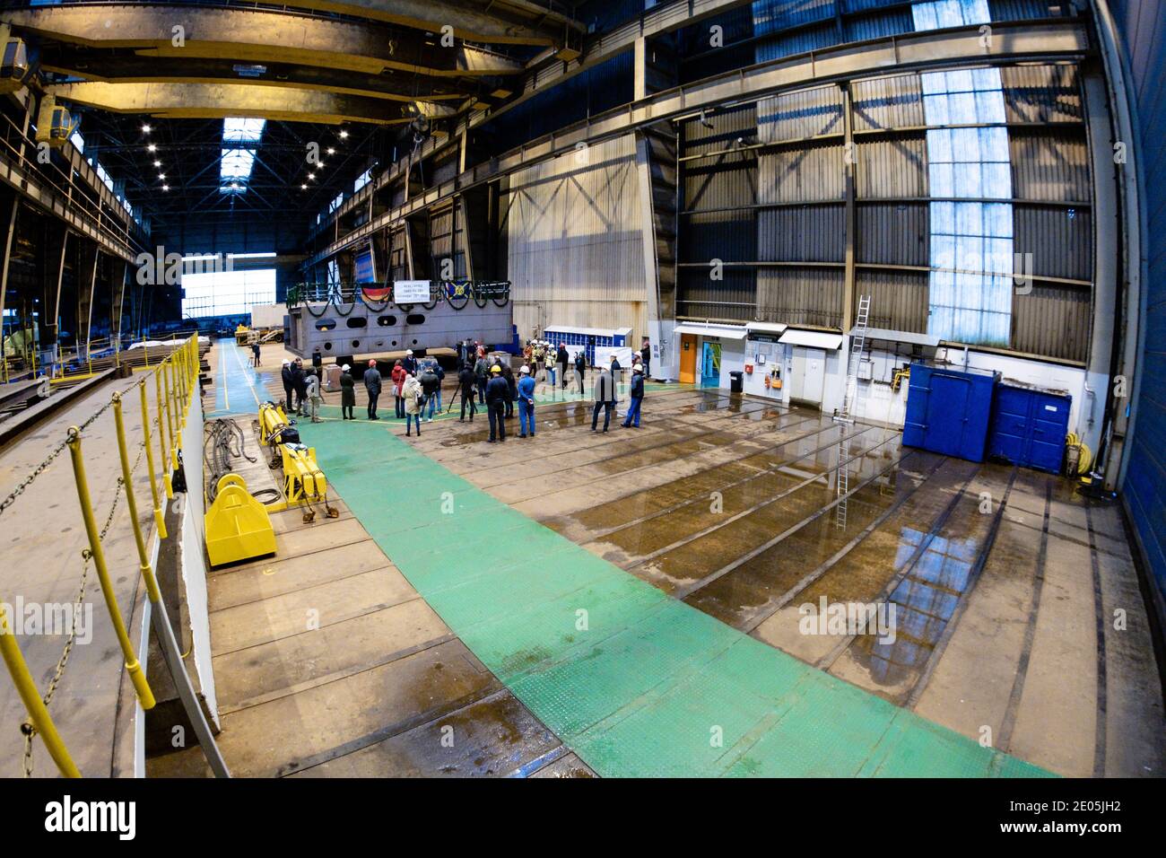 Flensburg, Deutschland. Dezember 2020. Die Teilnehmer einer Kielverlegung stehen vor einem Unterteil eines neuen RoRo-Schiffes auf der Flensburger Werft. Mit dem Neubau hat die angeschlagene Flensburger Schiffbau-Gesellschaft (FSG) ihren ersten Auftrag seit dem Relaunch unter der Leitung der Tennor Holding erhalten. IVP Ship Invest, ein Unternehmen des Tennor-Gründers Lars Windhorst, hat eine Ro-Ro-Fähre bestellt, teilte die FSG mit. Kredit: Frank Molter/dpa/Alamy Live Nachrichten Stockfoto