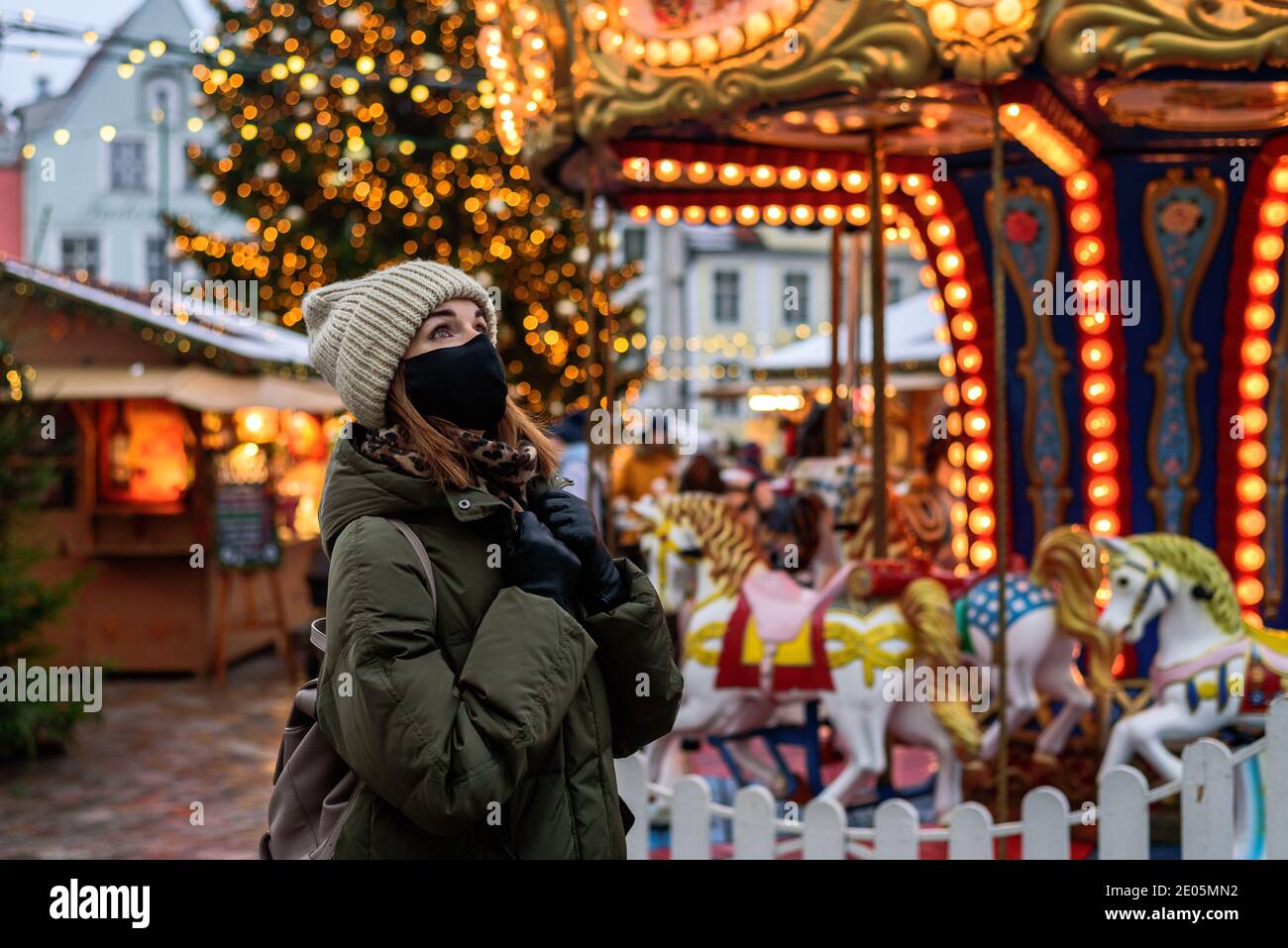 Frau in Gesichtsmaske auf dem Weihnachtsmarkt in Tallinn, Estland Stockfoto