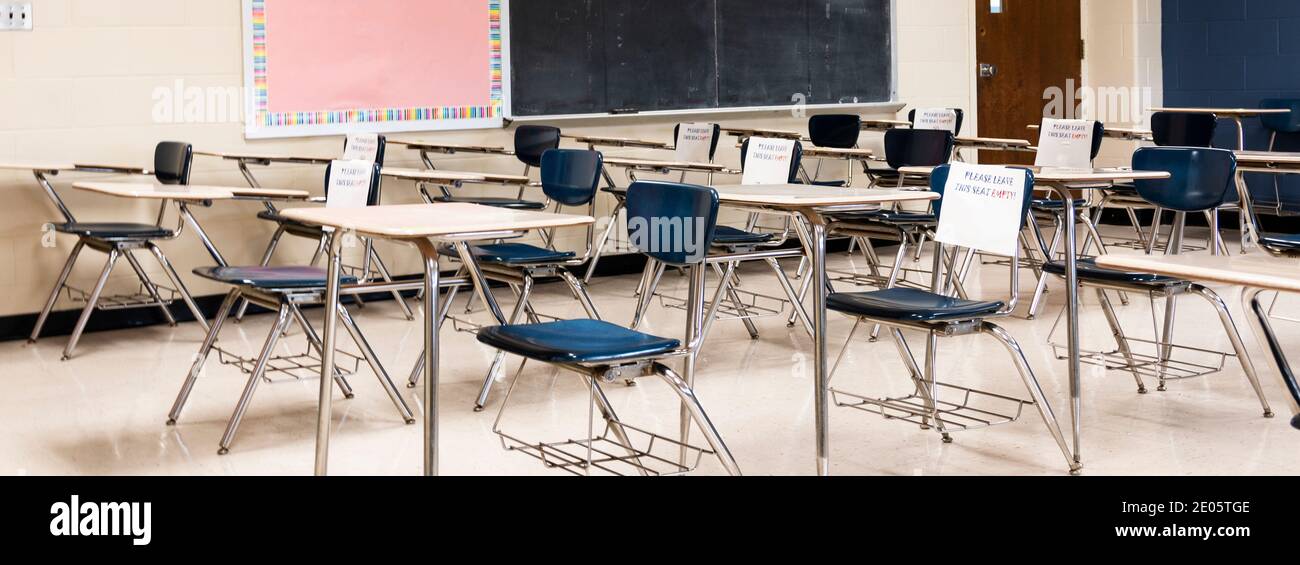 High-School-Klassenzimmer mit Schreibtischen als nicht verfügbar markiert, um Schüler sechs Fuß auseinander während der HE COVID-19 Coronavirus Pandemie zu halten. Stockfoto