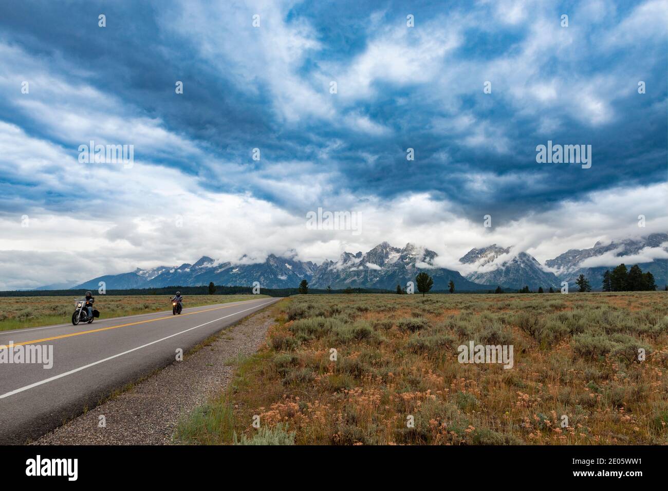 Wyoming, USA - 5. August 2014: Zwei Motorräder fahren entlang einer landschaftlich schönen Autobahn, mit den Grand Teton Bergen im Hintergrund, im Bundesstaat Wyomin Stockfoto