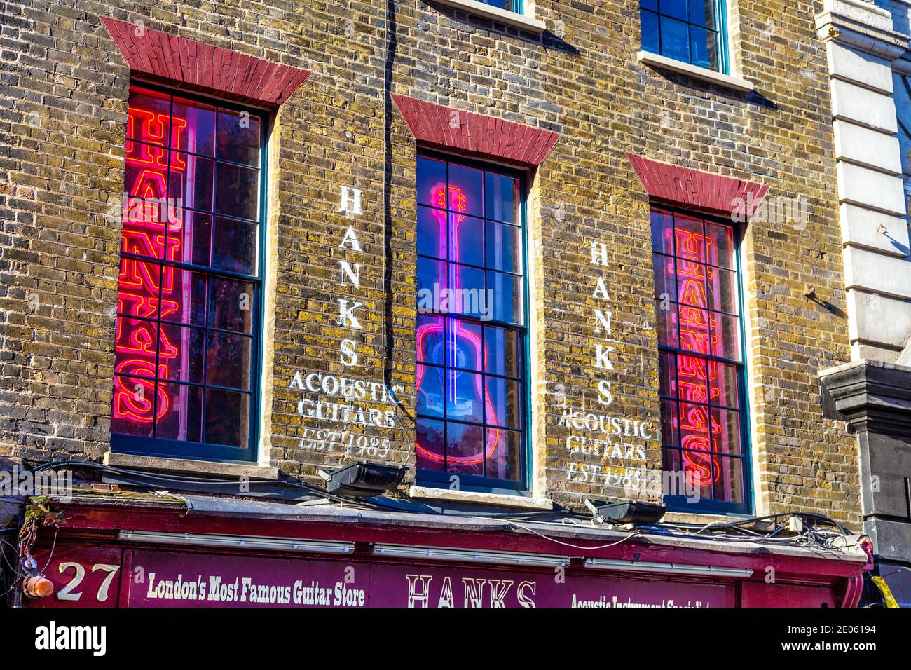 Neon-Schilder in den Fenstern von Hanks Acoustic Guitars Shop auf berühmten Musik Shop Straße - Denmark Street, London, UK Stockfoto