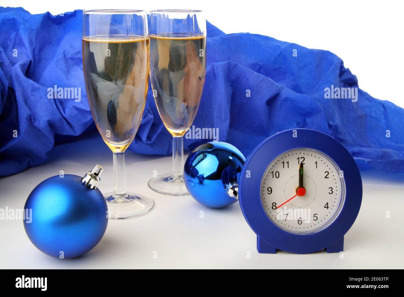 Konzept zur Feier des neuen Jahres. Zwei Gläser Champagner mit einer Uhr mit 12 Uhr und Weihnachtskugeln Stockfoto