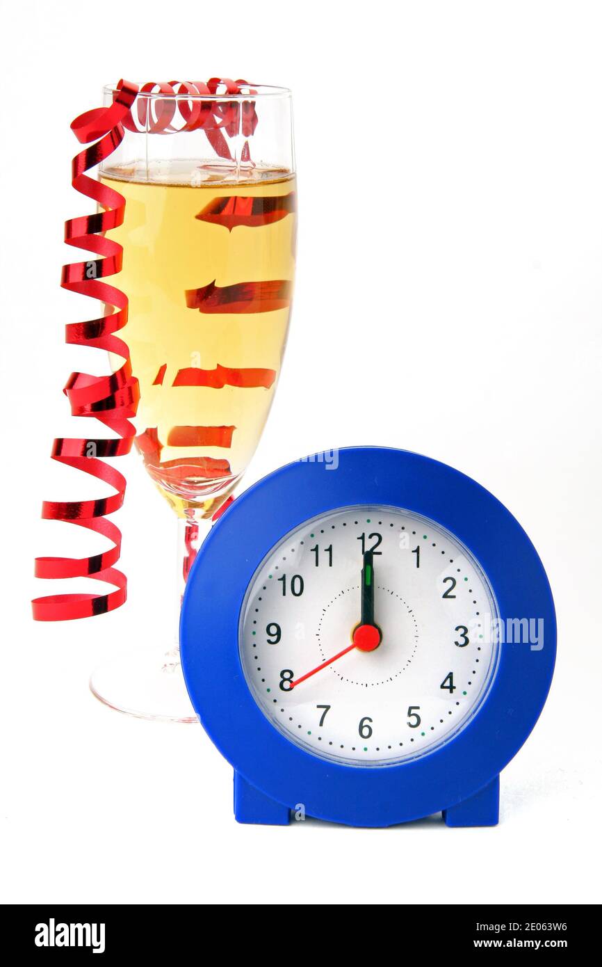 Neujahrsfest Konzept 12 Uhr. Ein Glas Champagner mit einer Uhr und einem festlichen Band auf weißem Hintergrund Stockfoto
