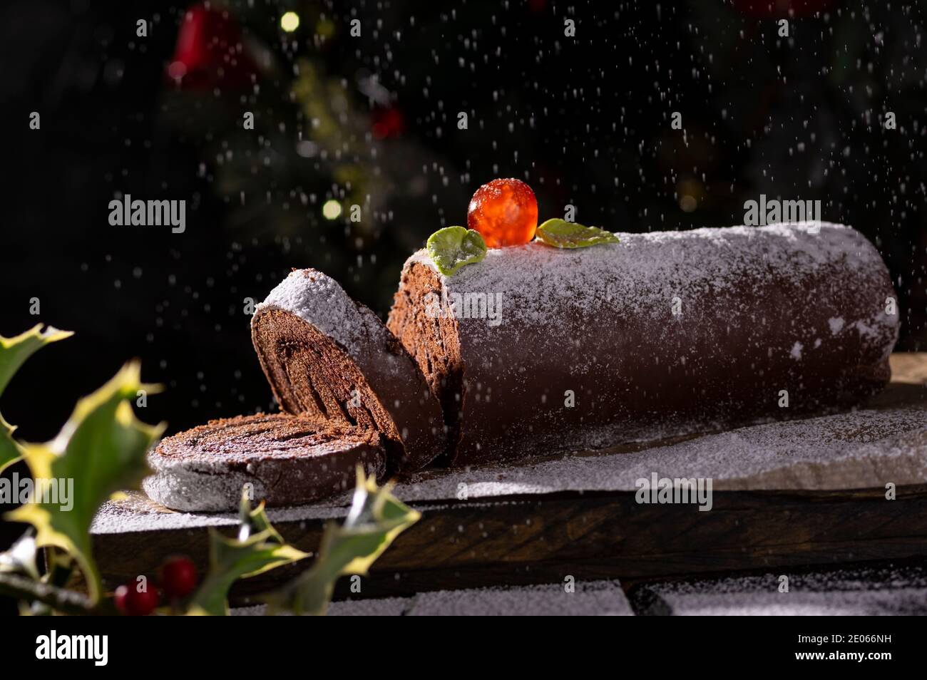 Schokolade schweizer Brötchen Kuchen Roulade mit Zuckerkirsche und dekoriert Puderzucker Stockfoto