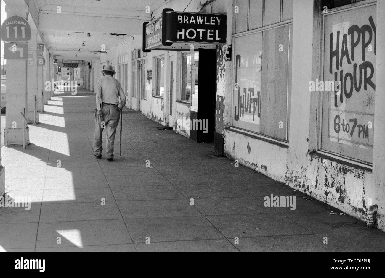 Senior Mann kratzt seine unteren städtischen Armut außerhalb der billigen und heruntergekommenen Brawley Hotel Werbung Happy Hour, Brawley, New Mexico 1972 1970er USA HOMER SYKES Stockfoto