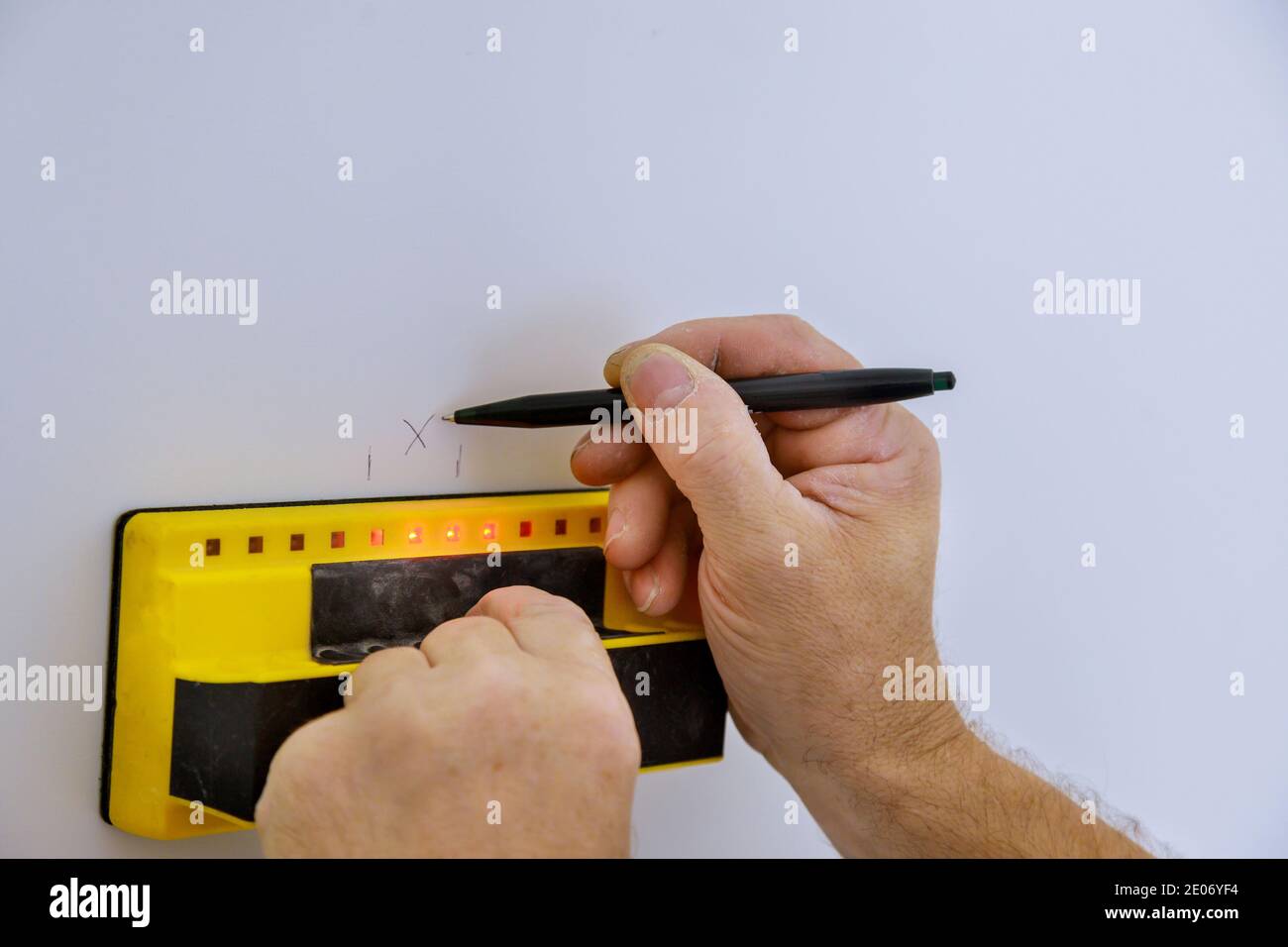 Der Digitaldetektor man Hand scannt die Wand mit der Präzision der Sensoren Stud Finder Holzbalken weichen Fokus Stockfoto