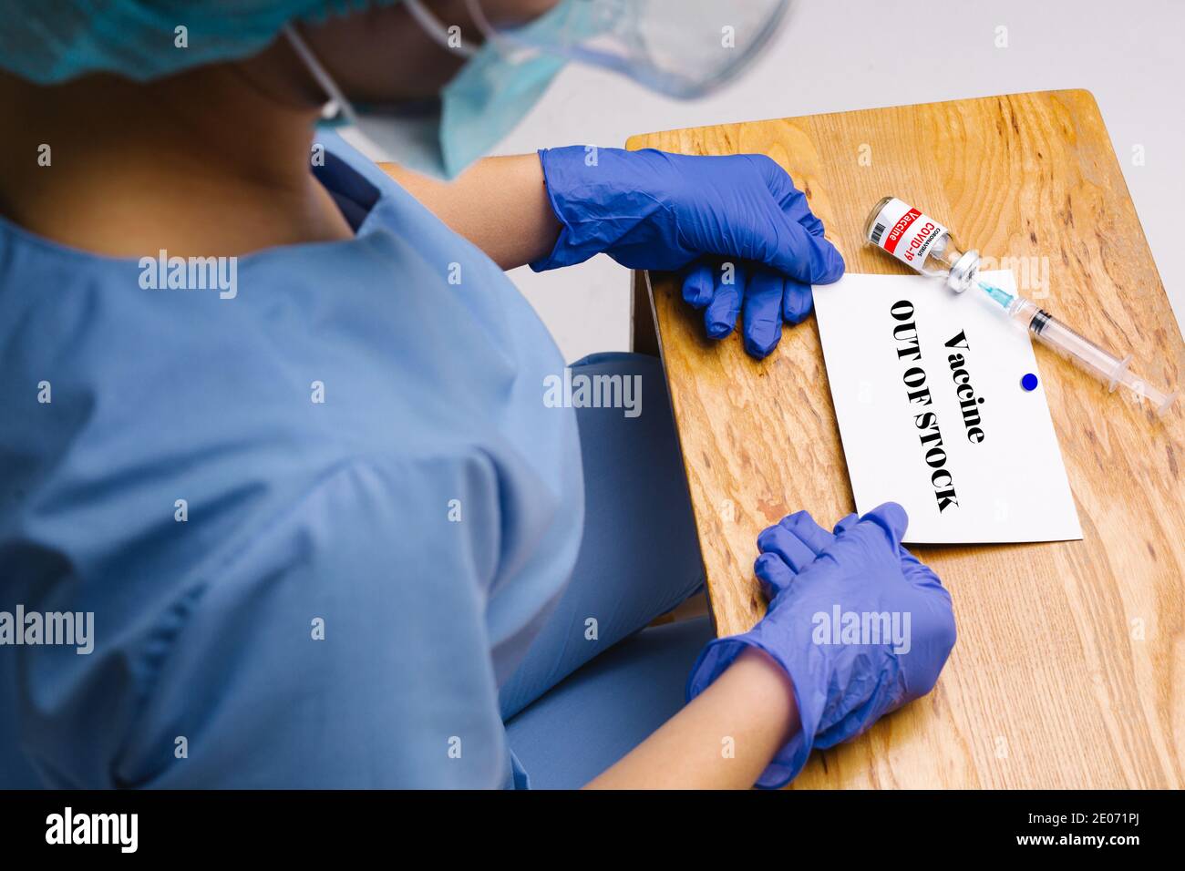 Vergrößertes Foto eines Gesundheitshelfer am Tisch mit einer Karte und einer Inschrift, die besagt, dass es Impfstoffe nicht auf Lager. Hochwertige Fotos Stockfoto
