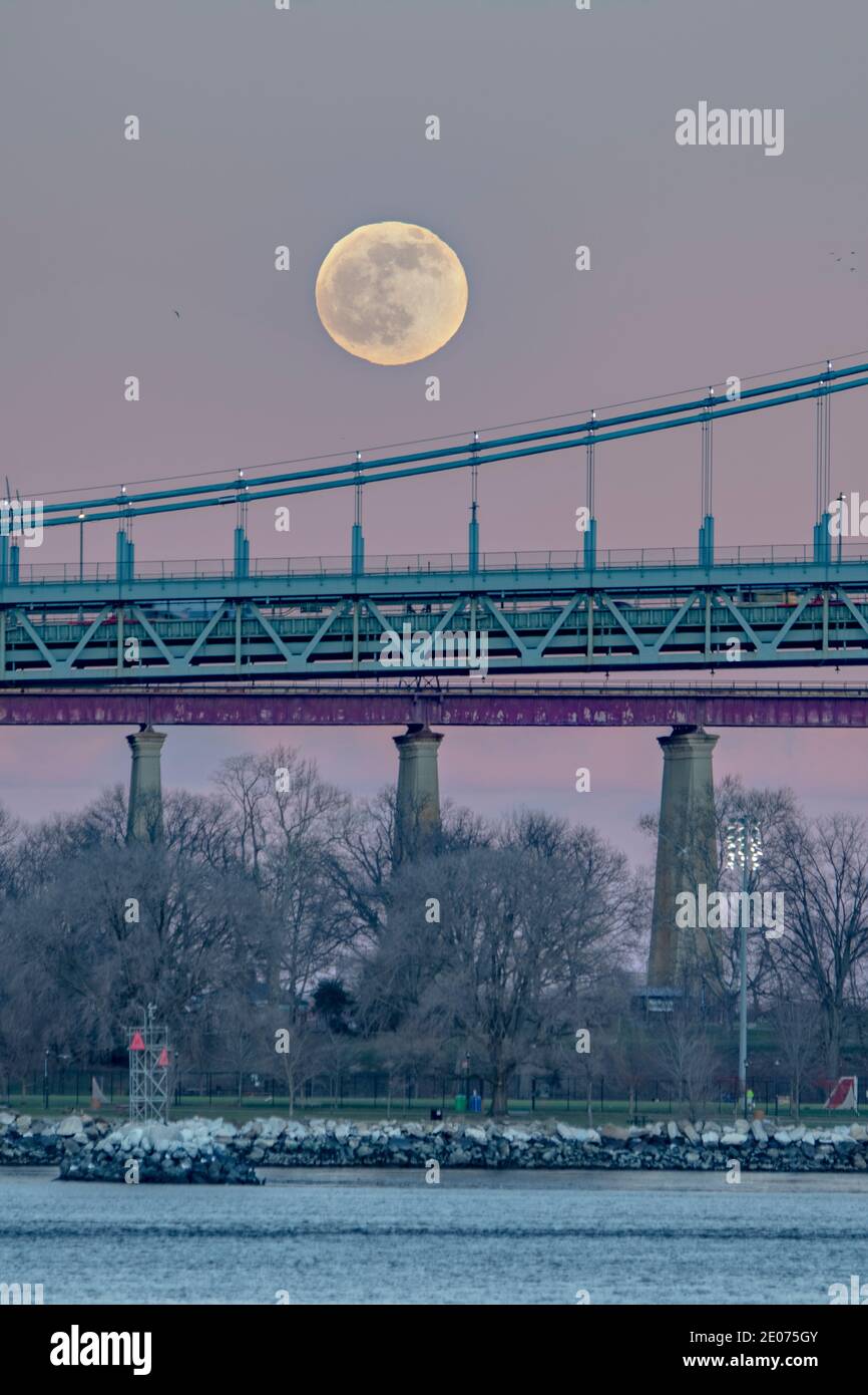 Mond steigt über New York City Brücken und East River Stockfoto