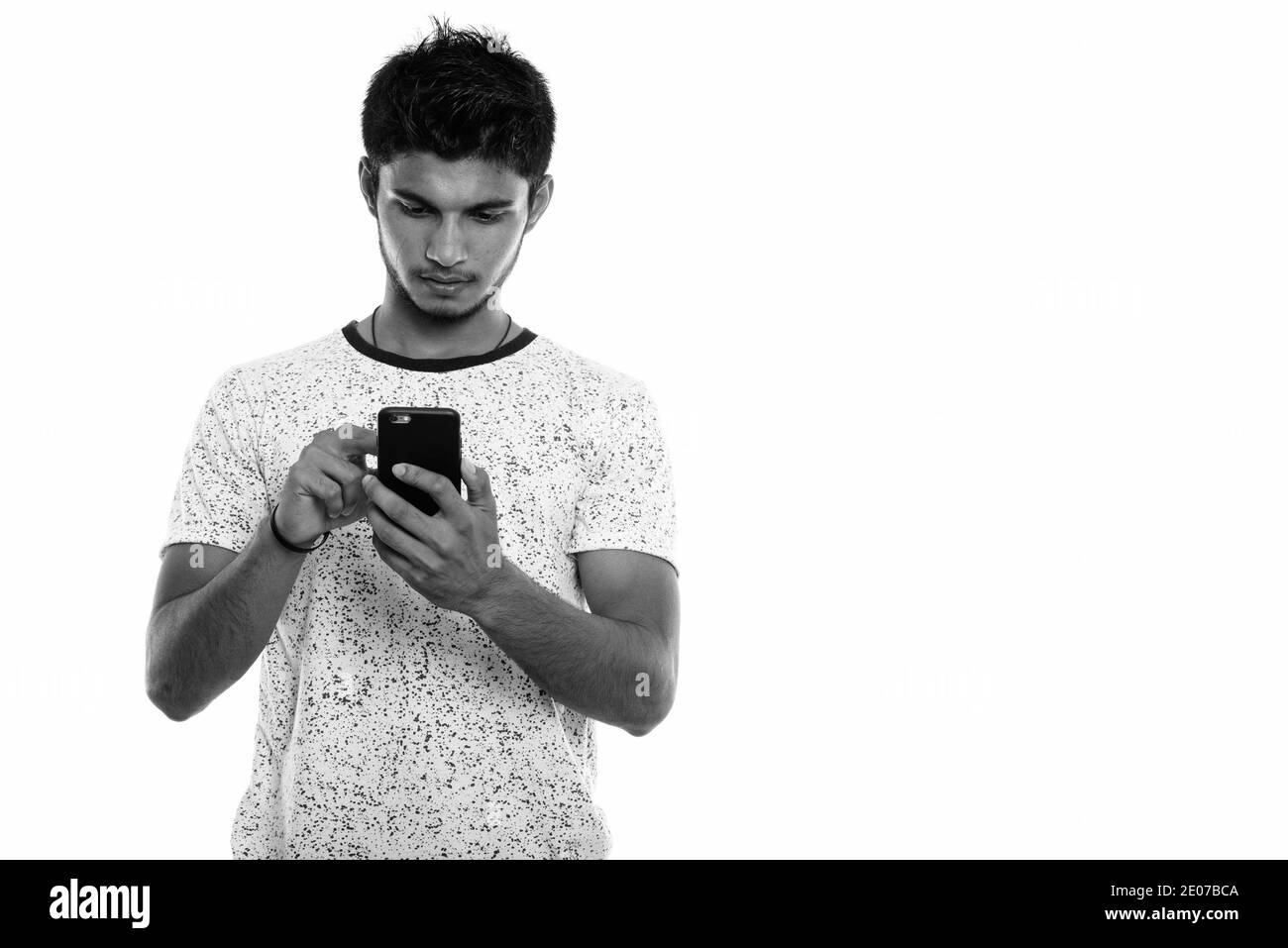Studio shot der jungen schönen Indischen über Handy Mann Stockfoto
