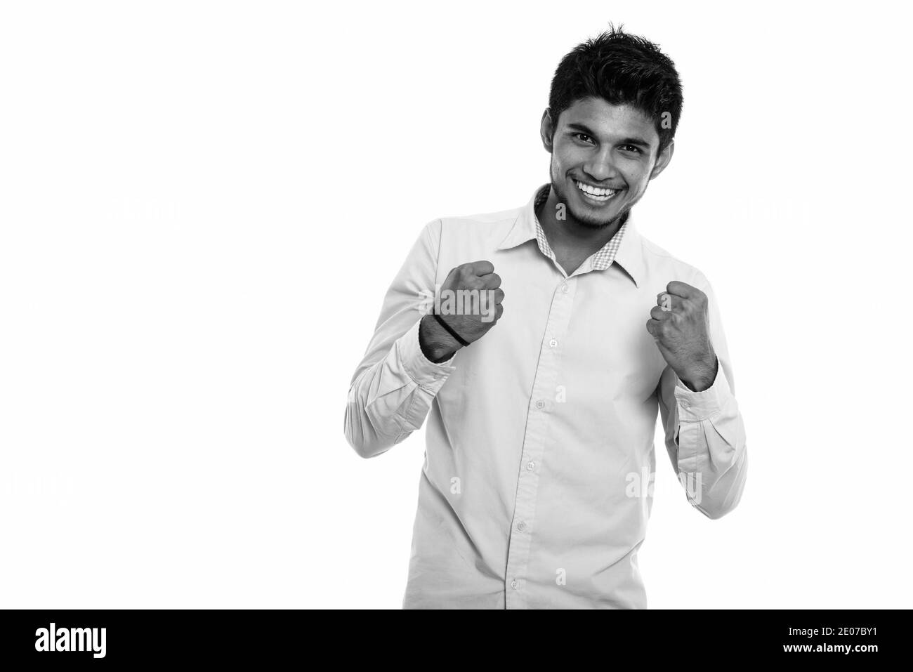 Studio shot junger indischer Mann glücklich lächelnd, während sie aufgeregt Stockfoto