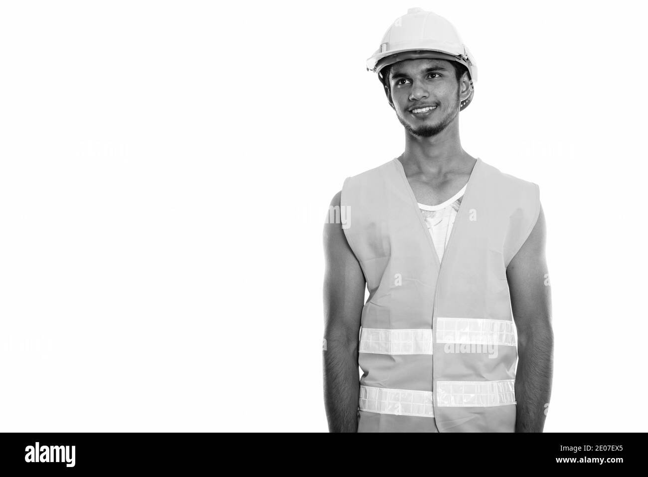Studio shot der Jungen gerne Inder Bauarbeiter lächeln und denken beim Suchen Stockfoto