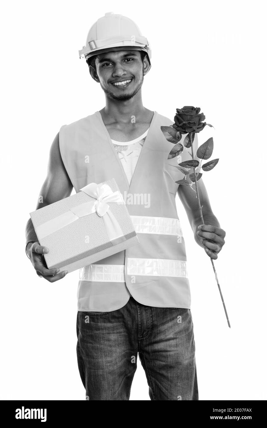 Junge glücklich Inder Bauarbeiter lächelnd, während sie rote Rose und Geschenkbox bereit für den Valentinstag Stockfoto