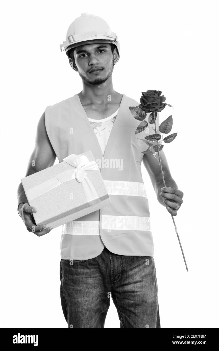 Junge schöne Inder Bauarbeiter mit roten Rose und Geschenk für den Valentinstag bereit Stockfoto