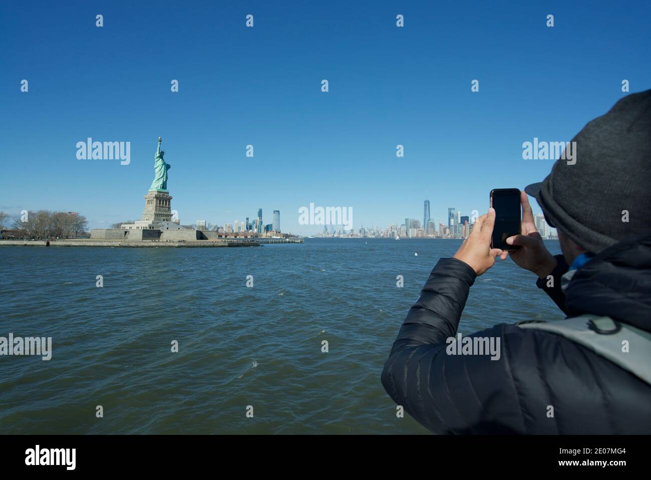 Tourist, der ein Foto von der Freiheitsstatue New York, New York City Statue, Liberty Island New York, NYC macht. Telefonfotografie. Touristen und Besucher Stockfoto