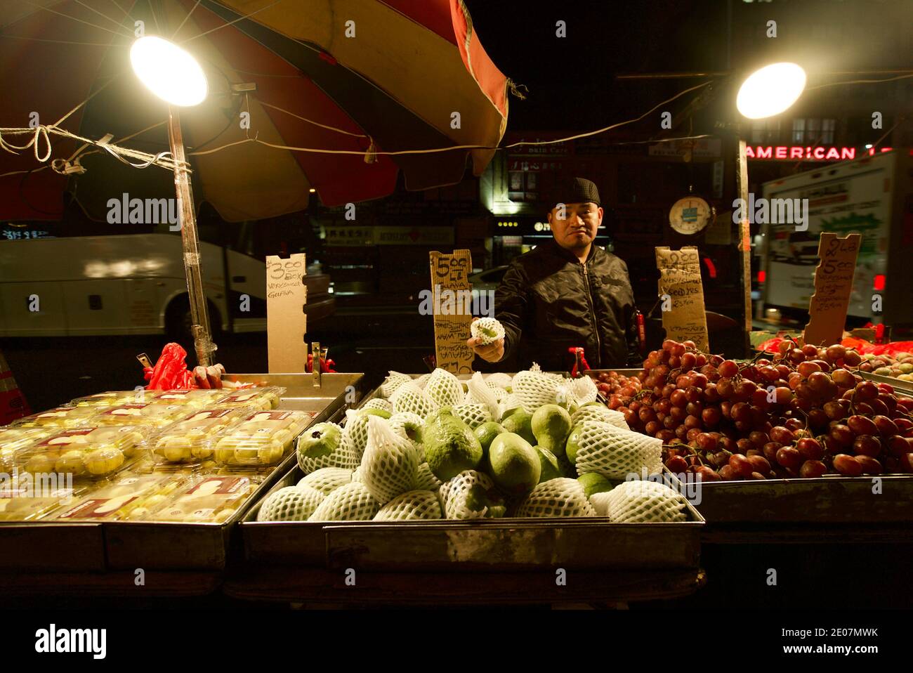 Ein Straßenhändler in Chinatown, New York, der Guava-Früchte und andere Früchte verkauft. Ein Mann, der Obst auf einem Markt in New York in China Town verkauft. Bowery. Stockfoto