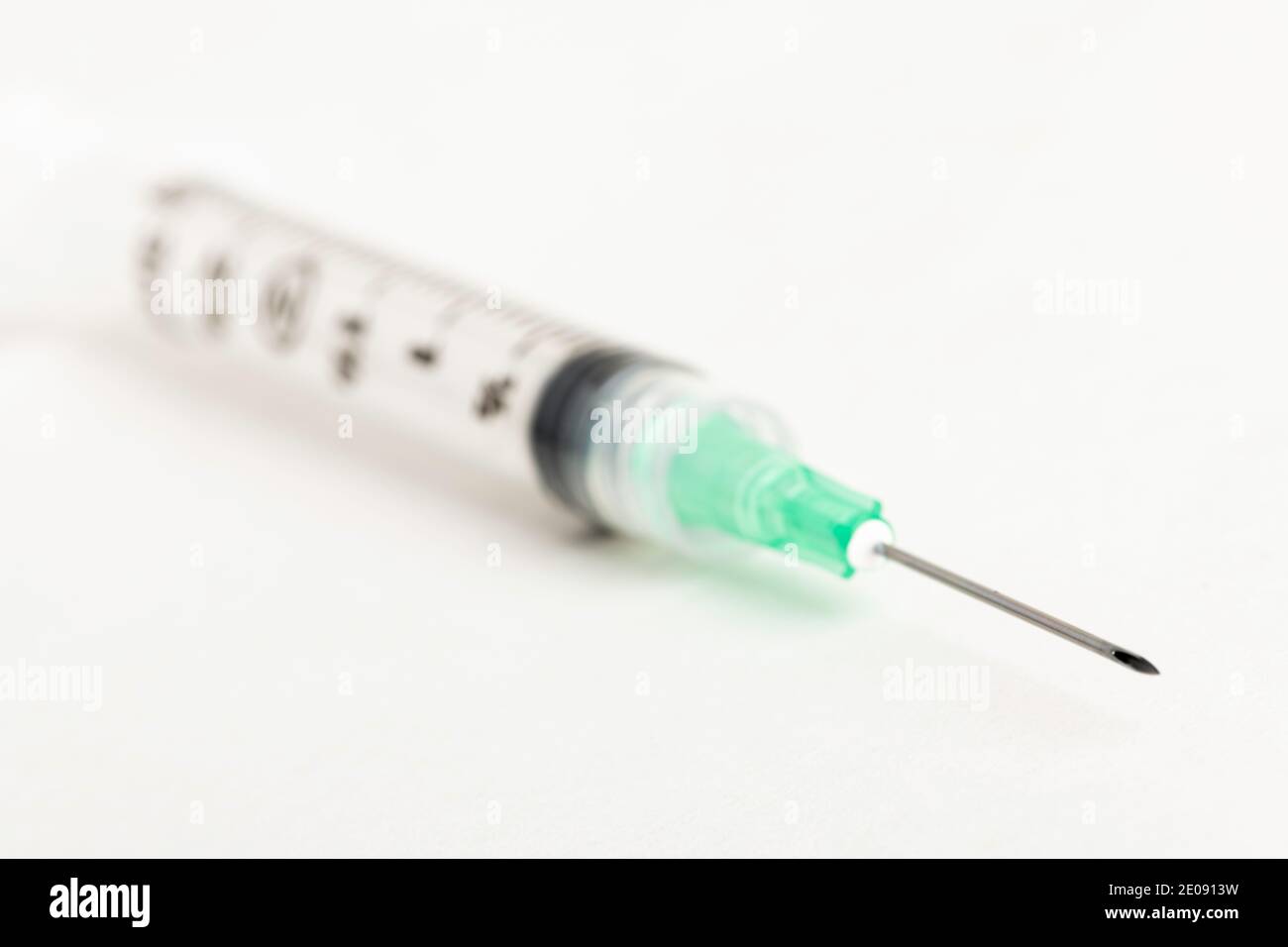 Eine Nahaufnahme mit selektivem Fokus auf einem hygienischen Einweg-Injektionsset aus Kunststoff auf weißem Hintergrund. Stockfoto