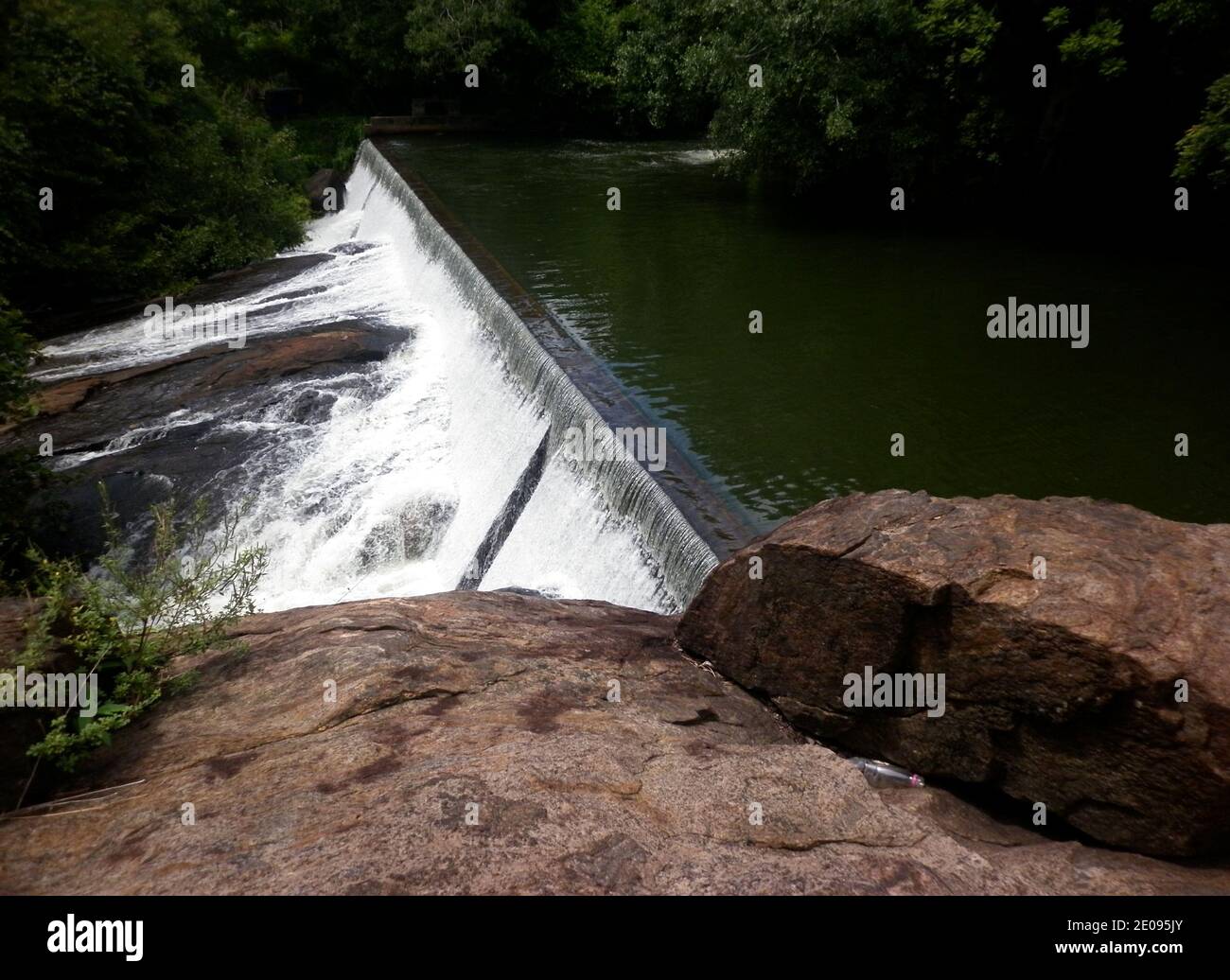 Schöne Aussicht von der Oberfläche von Felsen und weißem Schaum Wasser fließt aus einem Damm in einem Stausee Stockfoto