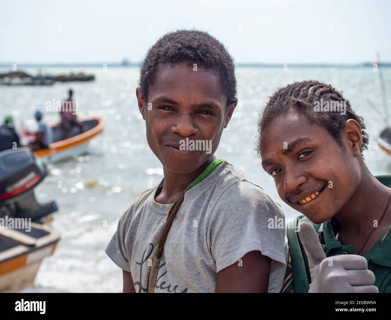Junge Männer hängen am Fährhafen in Wewak, der Hauptstadt der Provinz East Sepik in Papua-Neuguinea. Diese Schlauchboote werden für öffentliche T verwendet Stockfoto