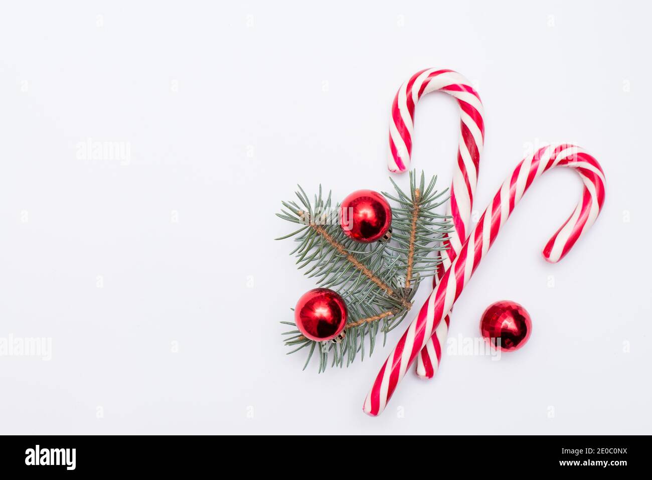 Weihnachtshintergrund mit Copyspace, Süßigkeiten und Neujahr roten Kugeln auf weißem Hintergrund Stockfoto