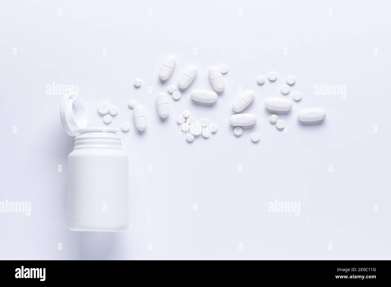 Verschüttete Pille Flasche isoliert.Draufsicht, pharmakologisches Konzept. Weiße Pillen Stockfoto
