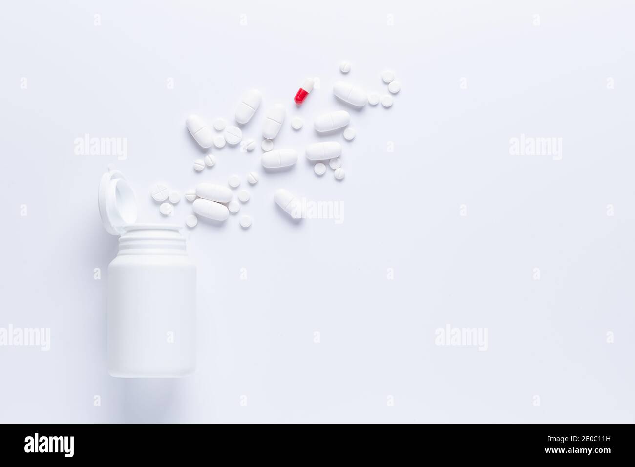 Verschüttete Pille Flasche isoliert.Draufsicht, pharmakologisches Konzept. Weiße Pillen ein rot. Stockfoto