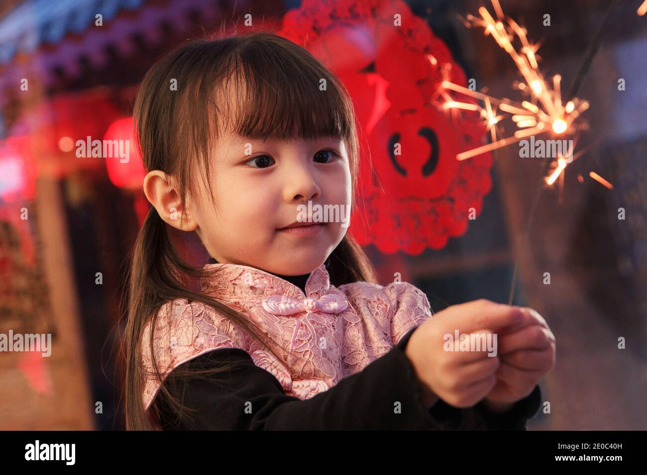 Das schöne kleine Mädchen mit Feuerwerk Stockfoto