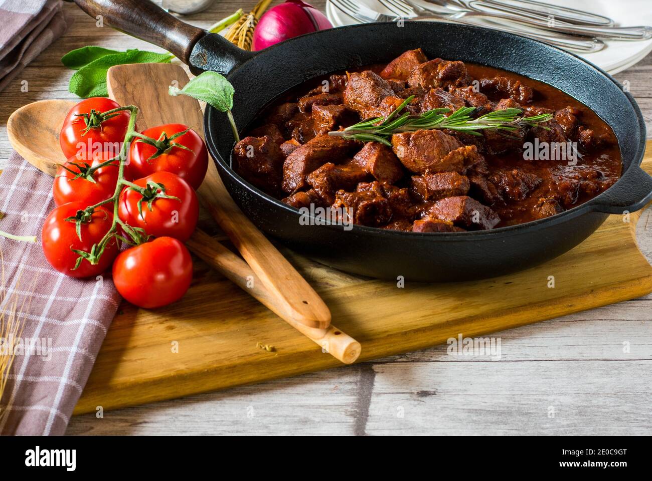 Italienische geschmorte Schweinefleisch Ragout mit köstlichen Rotwein,  Rosmarin, Tomaten, Knoblauch-Sauce in einer rustikalen Pfanne serviert  Stockfotografie - Alamy