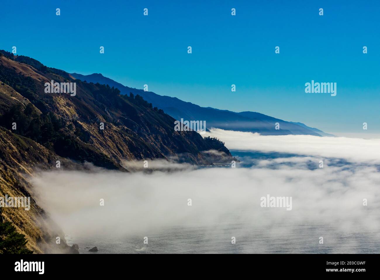 Nebel gleitet über das Meer und hinauf auf den Highway 1, California, USA Stockfoto