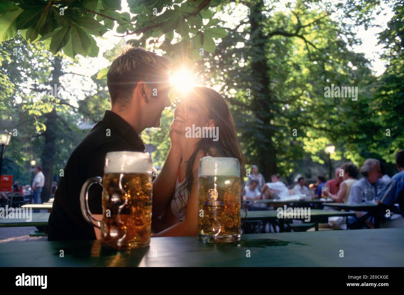 Deutschland /Bayern / München/glückliches junges Paar beim Biertrinken im Englischen Garten . Stockfoto