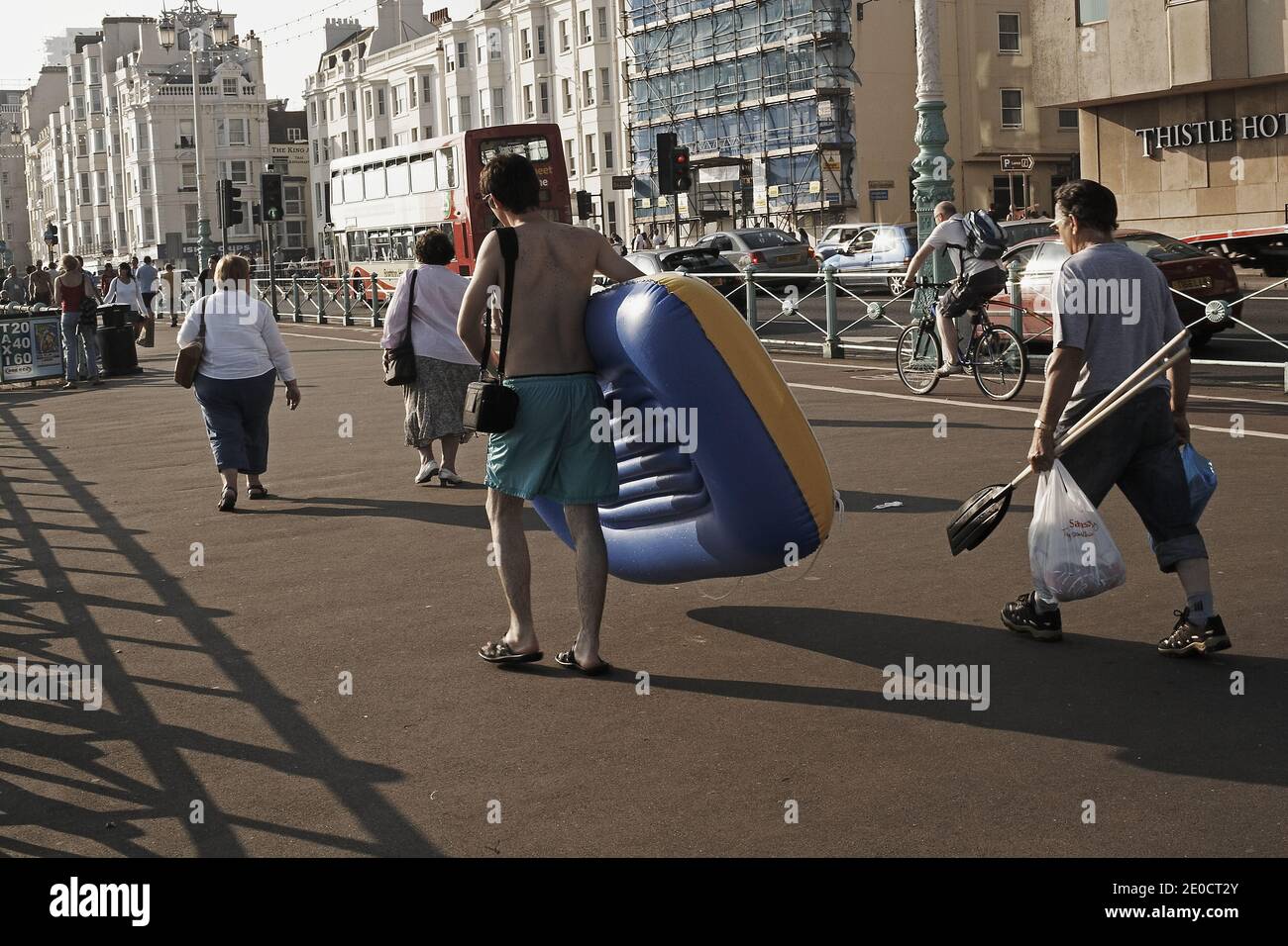GROSSBRITANNIEN / England / Brighton/ .man läuft mit einem aufblasbaren Spielzeugboot entlang der Brighton Promenade. Stockfoto