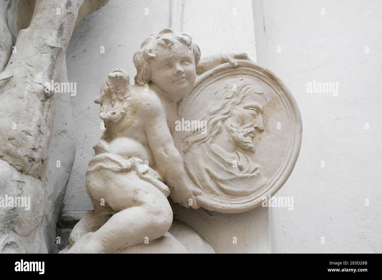 Engel, Cherub und Christkind halten Porträt von Jesus Christus. Statue und Skulptur im Barockstil. Stockfoto