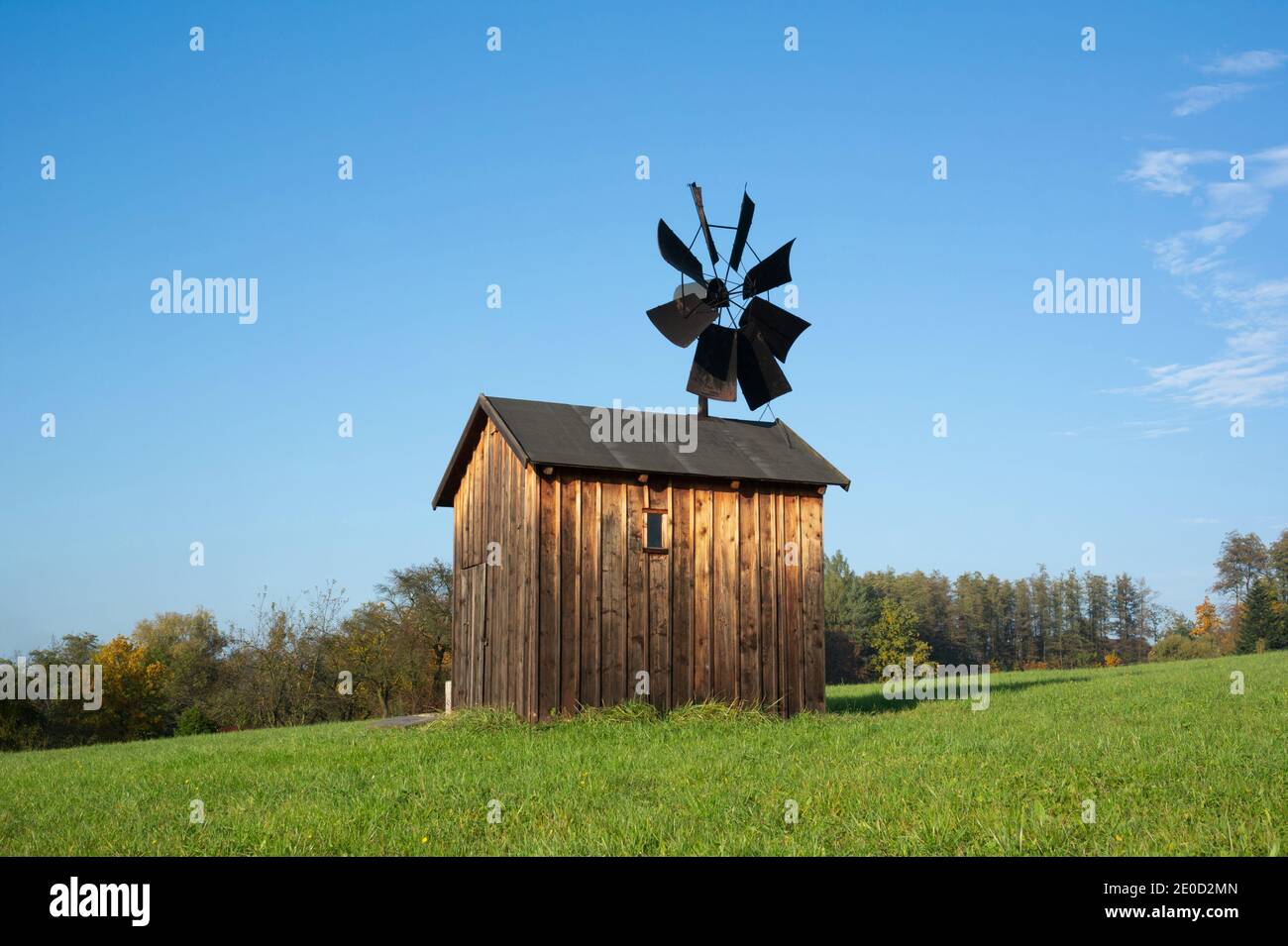 Alte verlassene Windmühle - Holzgebäude mit Propeller und Segel. Gerät und Technologie zur Erzeugung erneuerbarer Energie aus Windkraft. Architektur auf m Stockfoto