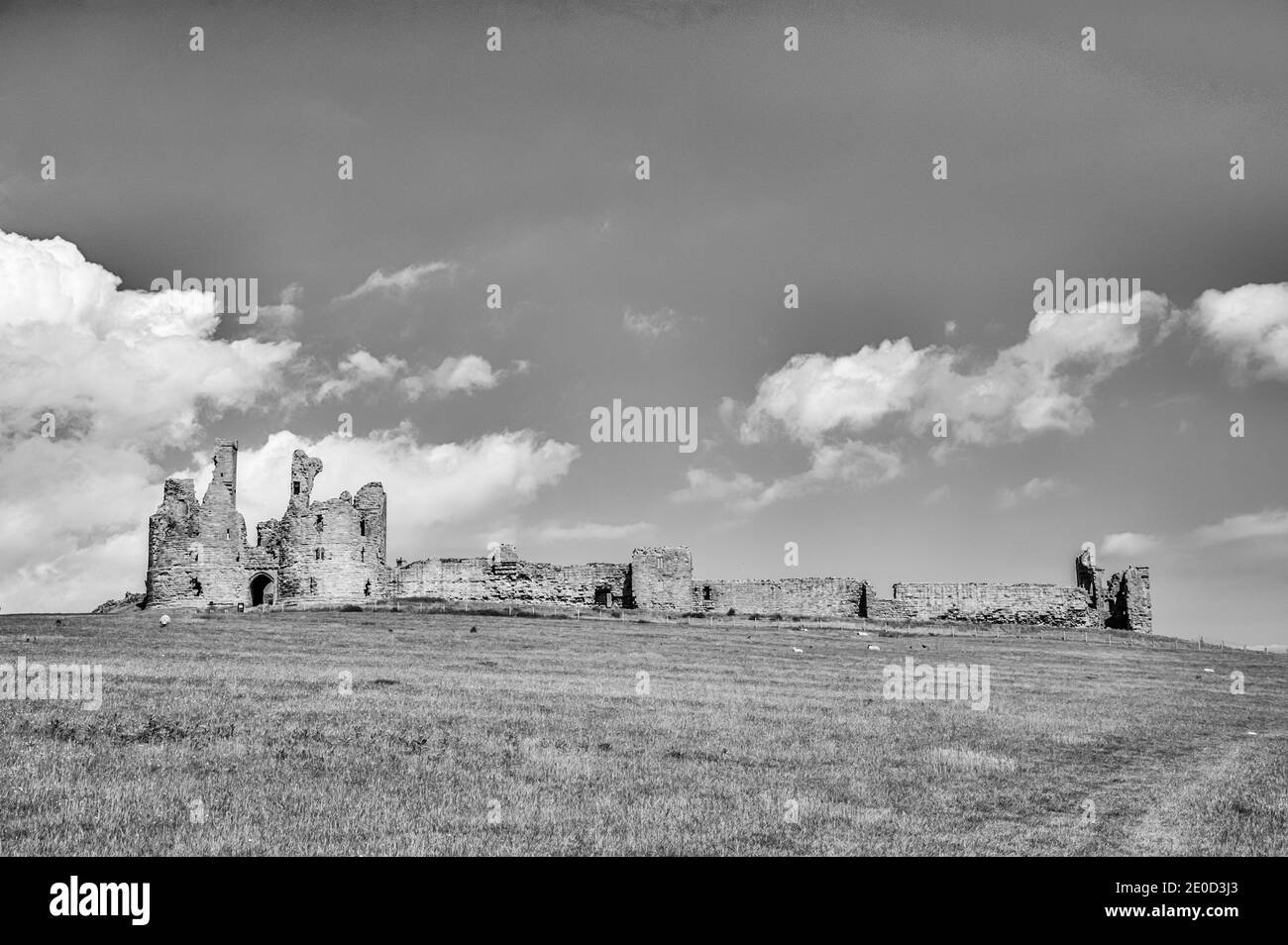 Northumberland. Dies sind die Ruinen von Dunstanburgh Castle, die den Sand der Embleton Bay in Northumberland im Nordosten Englands überblicken. Die Burg wurde nach dem Schutzpatron des blinden Heiligen Dunstan benannt Stockfoto