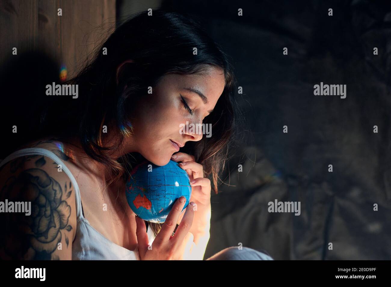 Seitenansicht einer ruhigen Frau mit geschlossenen Augen, die die Erde umarmt Globe zeigt Konzept der Rettung Planet Stockfoto