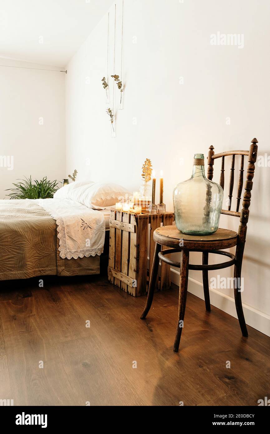 Minimalistischer Stil Home Schlafzimmer Innenarchitektur mit gemütlichen Bett und Holzmöbel in der Nähe der weißen Wand mit Boho Dekorationen platziert Stockfoto