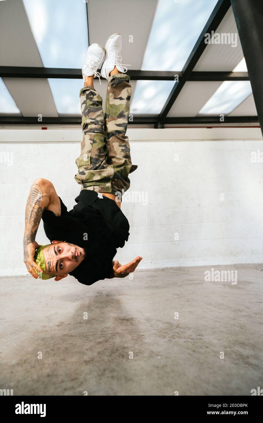 Voller Körper von energischen jungen Mann dabei akrobatische Handstand während Break Dance Stockfoto
