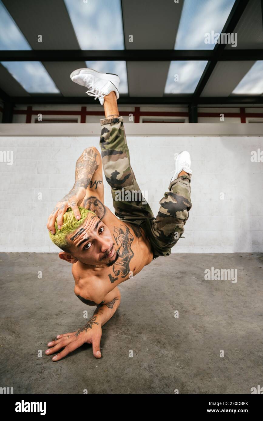 Voller Körper von energischen jungen Mann dabei akrobatische Handstand während Break Dance Stockfoto