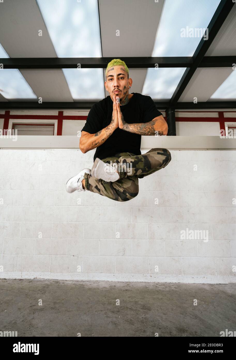 Ganzer Körper von jungen tätowierten Mann Durchführung Pause Tanz Bewegung Und über den Boden springen Stockfoto